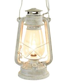 an old fashioned metal lantern with a light on it