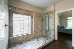 a bathroom with a walk in shower next to a window