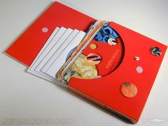 an open red folder with papers and magnets on the inside, sitting on a white surface