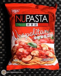 a bag of noodles with tomato sauce and shrimp in it on a black tablecloth