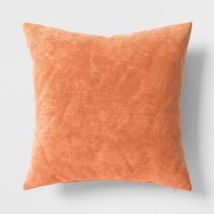 an orange pillow on a white wall