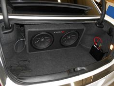 the trunk of a car with two speakers in it