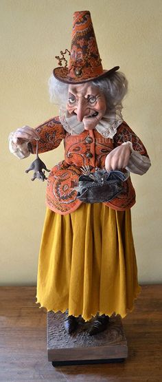 an old woman figurine is standing on a wooden table