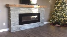 a living room with a christmas tree and a flat screen tv mounted on the wall