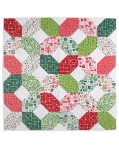 a quilted table topper with red, green and white squares on the side