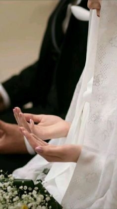 the bride and groom are sitting down with their hands together