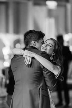 a man and woman hugging each other at a wedding