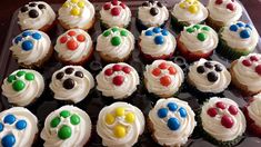 cupcakes decorated with white frosting and colorful paw prints