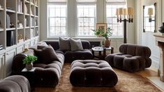 a living room filled with lots of furniture and bookshelves next to a fire place