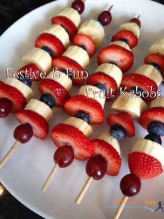 fruit skewers are arranged on a white plate