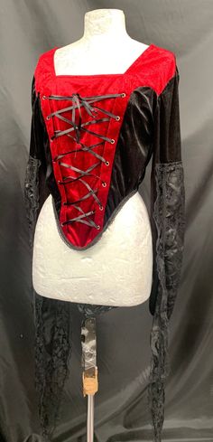 Rare find. This is an original Raven gothic black / Red corset top top . It has princess fiona sleeves fitted with finger ring and draped outer lace part , please refer to photos . The dummy the photo it taken on is a size 10 so I would say this top is a size 12/14 It does have stretch as it has Lycra side panels and a zip in the back Deadstock It is new with tags. Thank you for looking. Gothic Corset For Costume Party In Fall, Gothic Top For Costume Party In Fall, Gothic Tops For Costume Party In Fall, Punk Corset For Halloween Larp, Gothic Style Cosplay Top For Fall, Gothic Black Corset For Larp, Gothic Tops For Fall Costume, Black Gothic Corset For Larp, Gothic Long Sleeve Tops For Costume Party