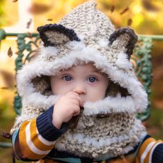 a small child wearing a knitted animal hat