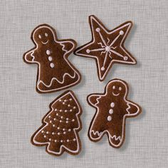 four decorated gingerbread cookies sitting next to each other