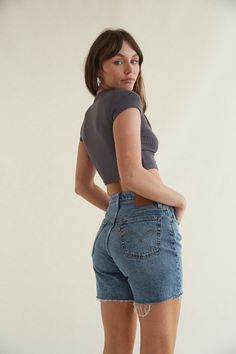 The Levi's 501 Mid Thigh Shorts will be your new spring and summer staple! These high rise denim shorts are relaxed throughout the hip and thigh and feature a raw-cut hem. Available in a light and medium wash. Style with your favorite crop top for a cute and casual look! Details 99% Cotton, 1% Elastane 5 pocket styling Belt loops Button fly Material has stretch Machine wash cold on normal cycle \ Wash inside out with like colors \ Do not bleach \ Tumble dry medium \ Hot iron \ Dry clean possible Levi’s Shorts, Long Short Outfits, Long Shorts Outfits, Long Denim Shorts Outfit, 2025 Wardrobe, Short Levis, Baggy Clothes Aesthetic, Long Jean Shorts, Long Denim Shorts