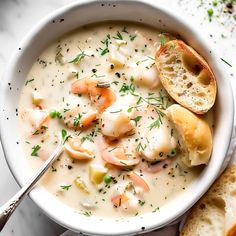 a white bowl filled with shrimp chowee and bread on top of a marble table