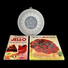 two cookbooks and a jello book on a black background