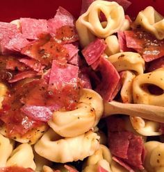 a red bowl filled with pasta and ham