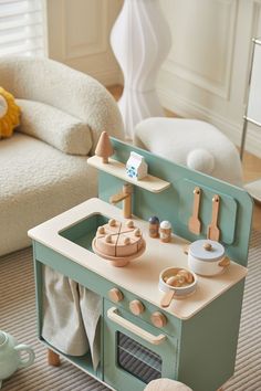 a wooden toy kitchen set in a living room