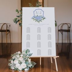 a table plan with flowers and greenery sits on the floor in front of chairs