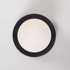 a black circular object on a white surface