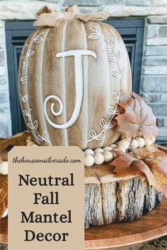 a wooden pumpkin sitting on top of a table next to leaves and acorns