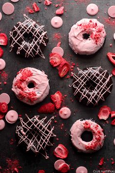 chocolate donuts with pink frosting and sprinkles on a black surface