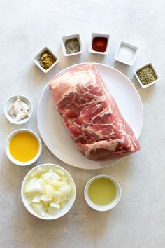 raw meat on a plate surrounded by spices and condiments