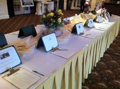 a long table with several items on it and flowers in vases at the end