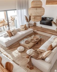 a living room filled with white furniture and lots of natural decor on top of it