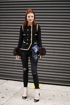 a woman with red hair wearing black and gold