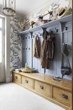 a coat rack with hats and coats hanging on it's sides next to a window