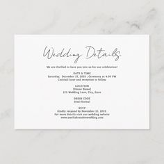 the wedding details card is displayed on a marble surface, with white text and black ink