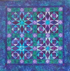 a blue and purple quilt with many different designs