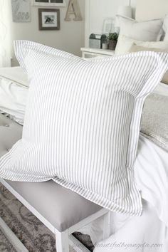 a white bed with two pillows on top of it