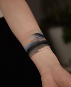 a person's arm with a wristband that has an abstract design on it