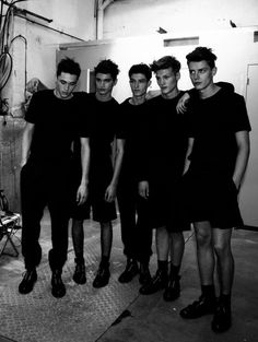 black and white photograph of five young men standing in front of an industrial machine room