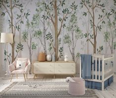 a baby's room with a crib, dresser and tree mural on the wall