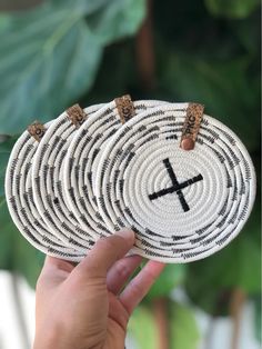 a person holding up a woven coaster with a cross on the front and two crosses on the back