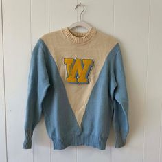 "Vintage Authentic Pieced Knit Cheerleading Sweater Incredible color-blocked and pieced V- shape Ribbed turnback cuffs Custom \"W\" Boucle stitched on patch that reads \"Shar\"  Faded name on tag says \" Sharon Wiig\"  Slight wear and pilling but overall great vintage condition   100% Wool Albion Knit : Made in Los Angeles No size label but fits like a Medium  Length from shoulder to hem (flat) - 20 in  Width from armhole to armhole (flat) - 16.5 in" Sporty Patchwork Sweater For Winter, Varsity Sweater For Game Day In Winter, Retro Color Block Sweater For Winter, Retro Color Block Winter Sweater, Retro Winter Color Block Sweater, Game Day Crew Sweater For Winter, Game Day Winter Crew Sweater, Blue Varsity Sweater For Fall, Vintage Letter Print Sweater For Winter