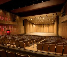 an empty auditorium with rows of chairs facing the stage