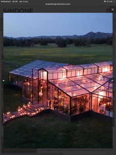 an aerial view of a glass house with candles in the windows and lights on the ground