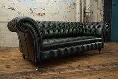 a black leather couch sitting on top of a wooden floor