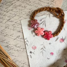 a bracelet with flowers on it sitting on top of a piece of paper