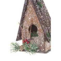 a birdhouse with snow on the roof and pine branches in front of white background