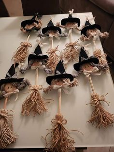 a table topped with lots of scarecrows on top of wooden stick holders filled with brooms