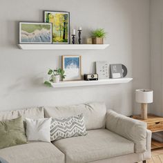 a living room filled with furniture and framed pictures on the wall above a white couch