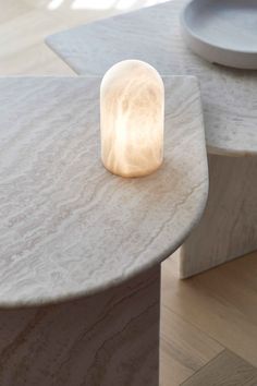 a table with a light on top of it next to a white plate and bowl