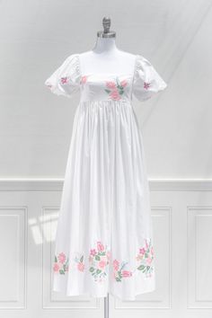 An eye catching summer dress, the Florentina features vibrant floral embroidered on the bodice and hem on a white linen-blend. A smocked elastic back and gentle a-line silhouette make for a comfortable and flattering fit. Perfect for a statement vacation piece, or to simply stun while out and about this summer! .. Deta White Embroidered A-line Dress For Spring, Spring A-line Smocked Dress With Smocked Bodice, Feminine Summer Floral Print Embroidered Dress, Spring Smock Dress With Square Neck, Spring Cotton Smocked Dress For Brunch, Cotton Smocked Dress For Garden Party With Short Sleeves, Feminine Spring Dress With Embroidered Hem, Feminine Dress With Embroidered Hem For Spring, Spring Empire Waist Cotton Dress