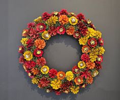 a wreath made out of fake flowers on a gray wall next to a grey wall