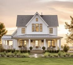 a large white house sitting on top of a lush green field